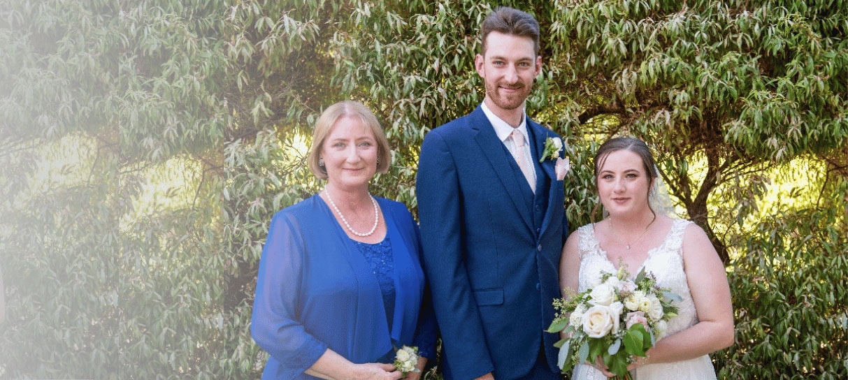 Judith (left) smiles with her son and daughter-in-law at their wedding