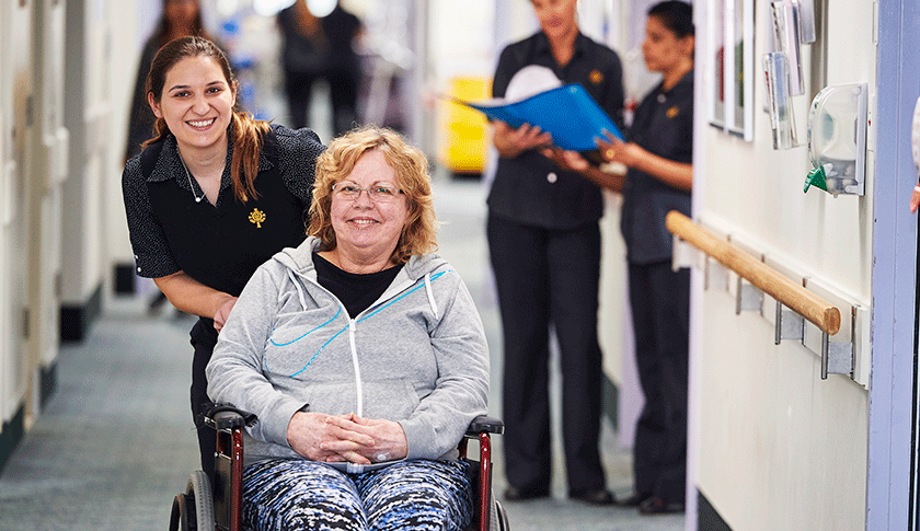 Caregiver pushing patient in wheelchair