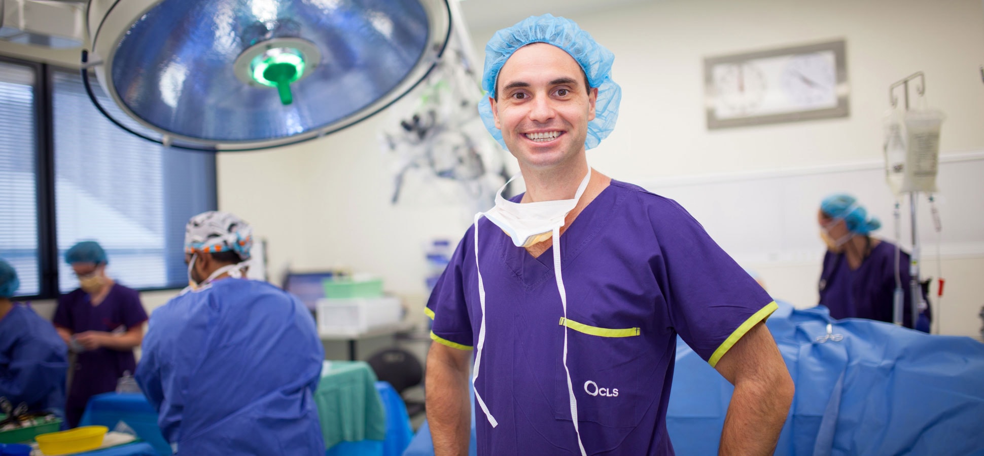 Dr David Oehme standing in theatre wearing scrubs and PPE