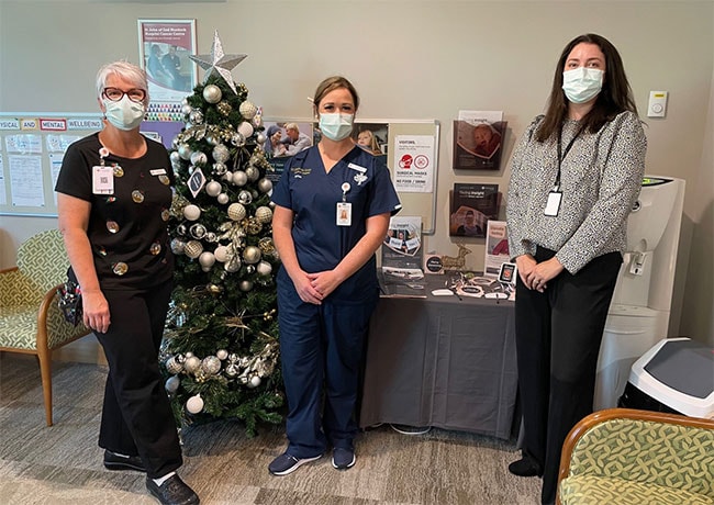 three hospital caregivers in front of christmas display