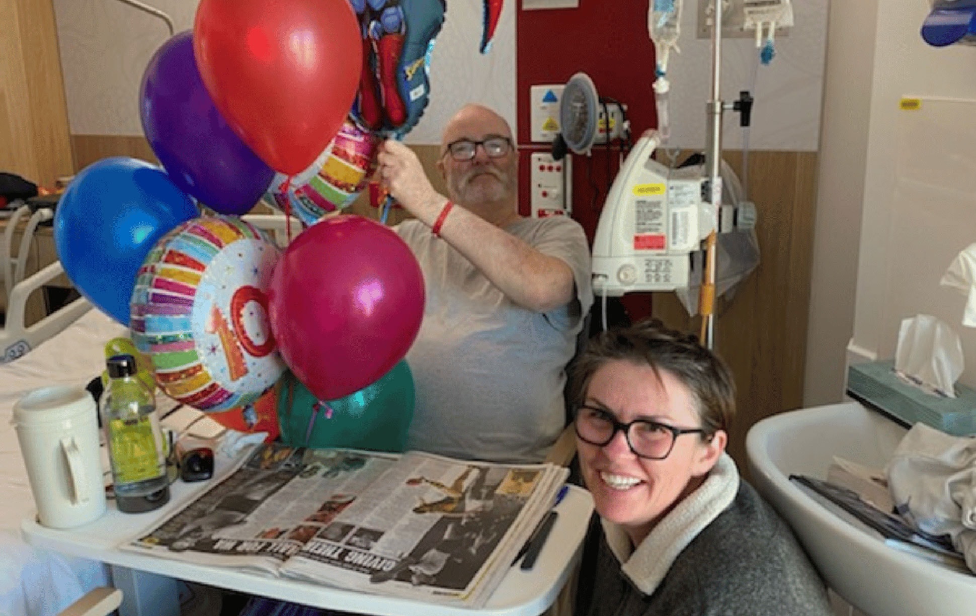 Perth musician, husband and father Errol Tout and wife Sandie in a patient room surrounded by helium balloons
