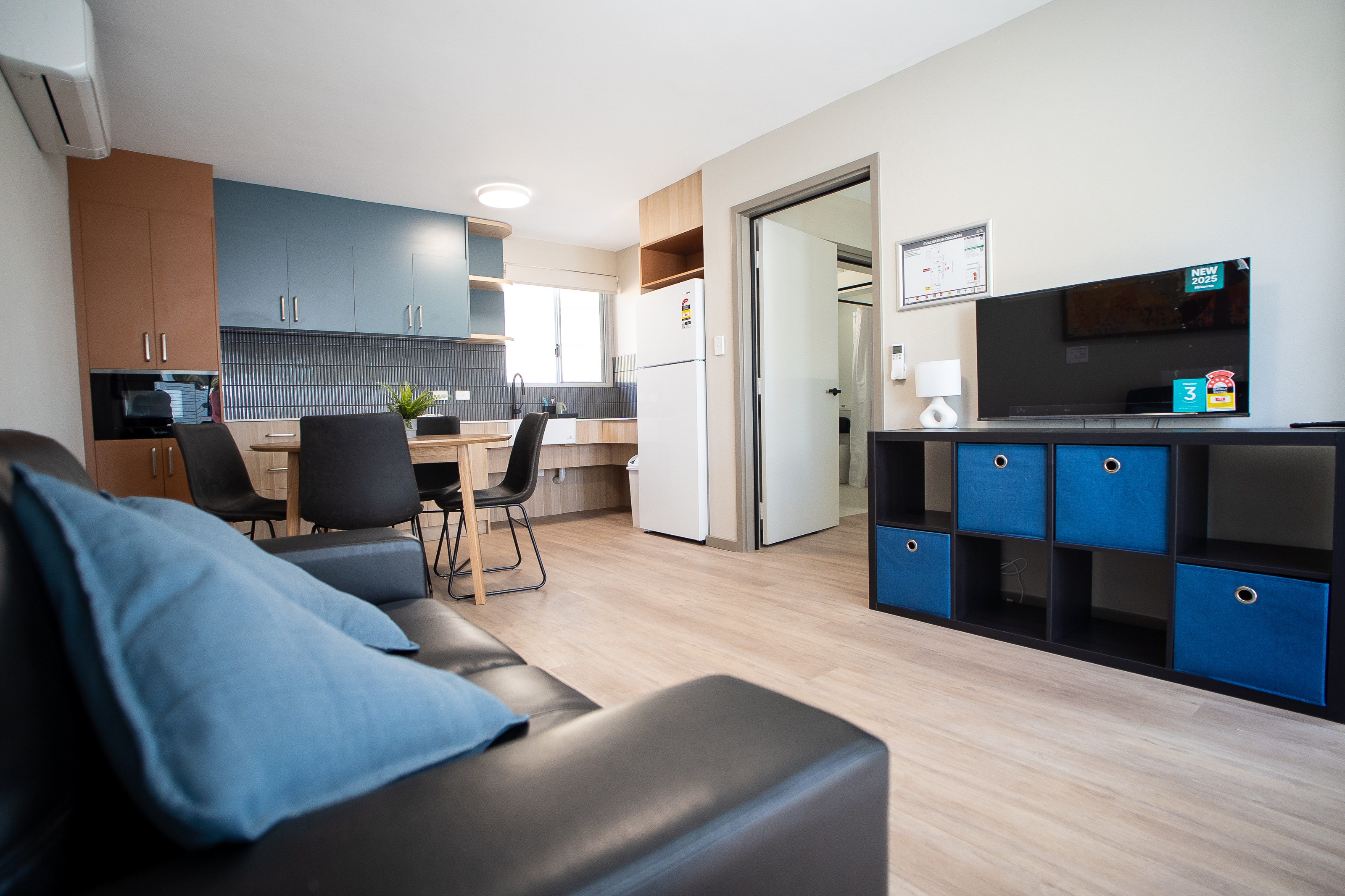 A room with a couch, kitchen and tv