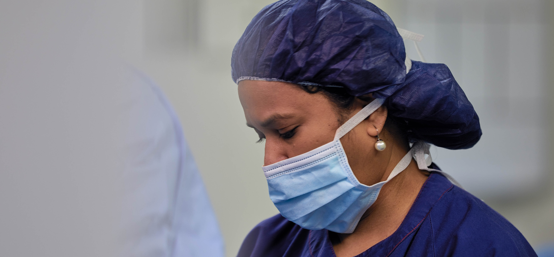 Theatre nurse in scrubs, mask and cap