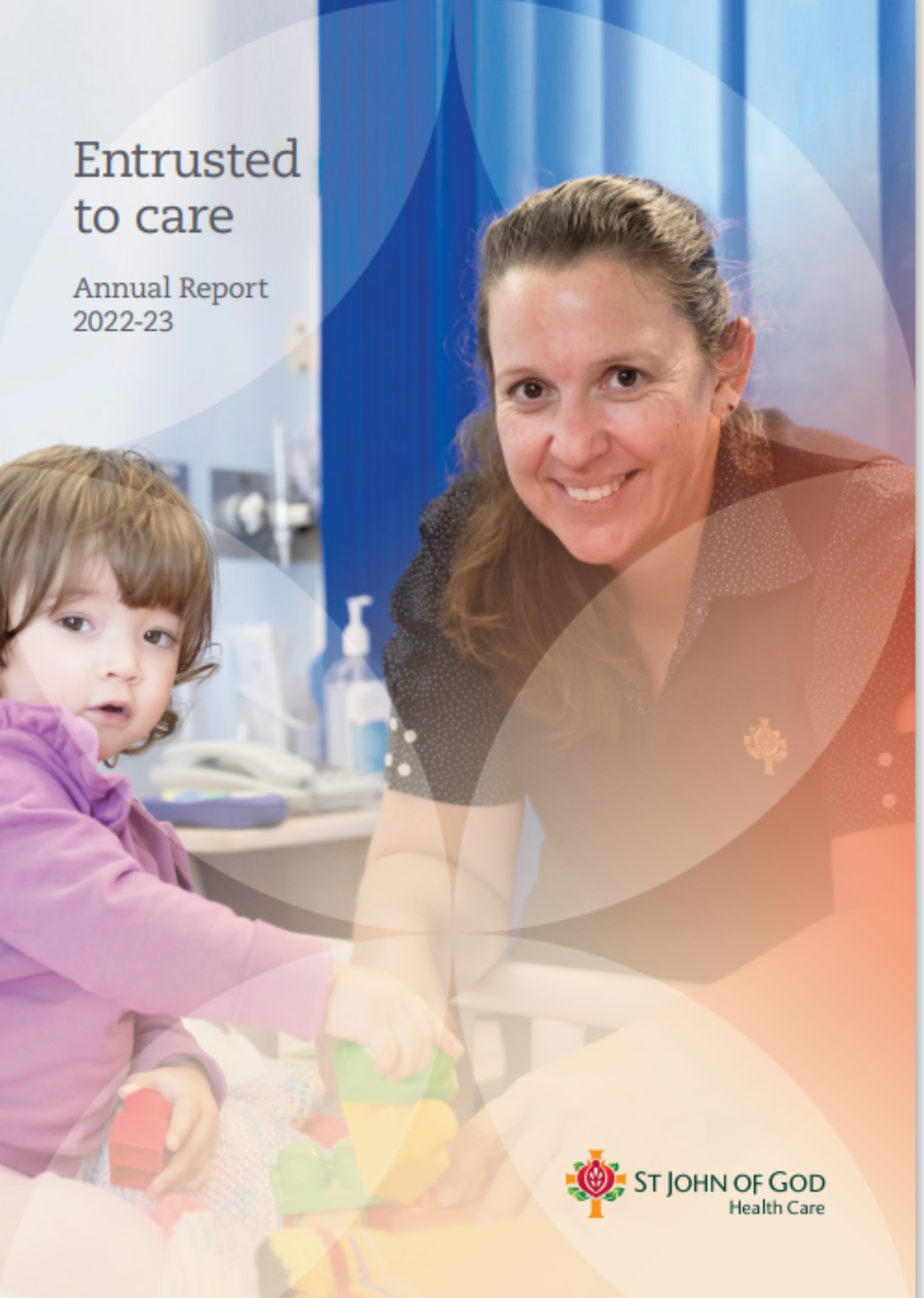 Cover of the St John of God Health Care Annual Report 2022-23, which features a caregiver smiling, playing with a small child in a hospital bed.