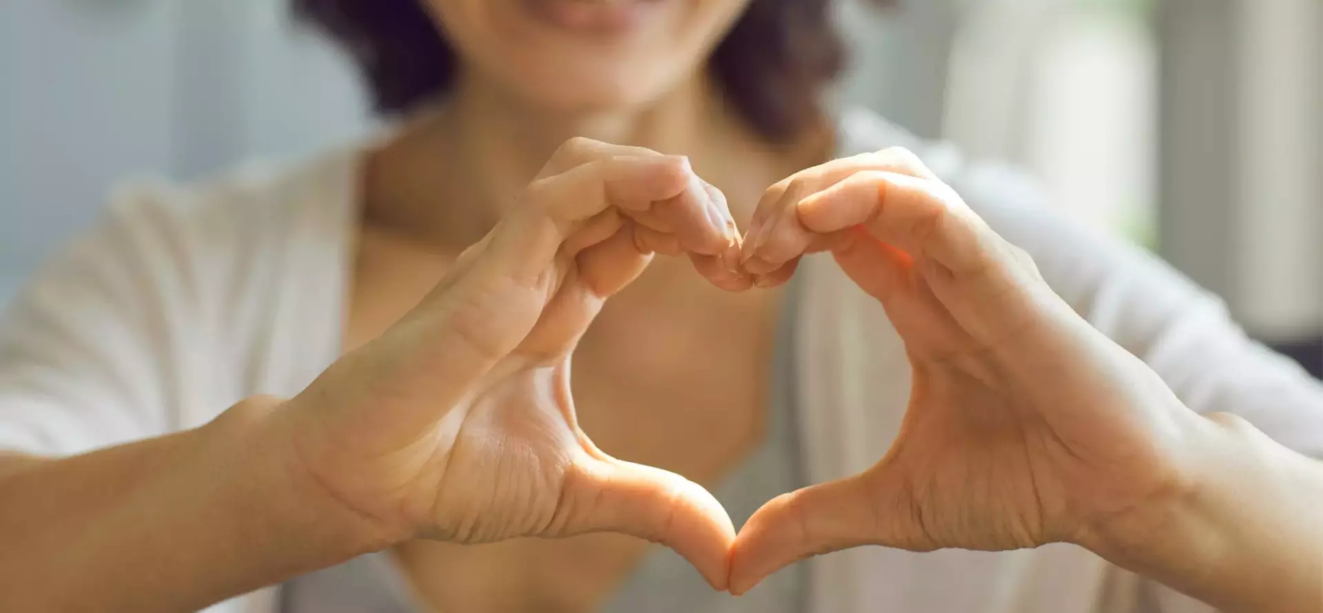 2 hands coming together to form the shape of a heart.