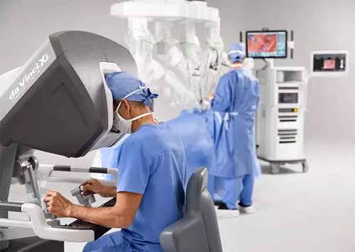 A surgeon in scrubs uses the da Vinci Xi robot.