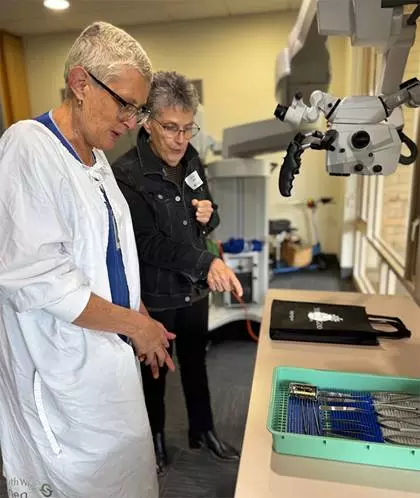A guest and caregiver viewing robotic surgical equipment.