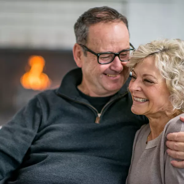 Husband and wife hugging and smiling.