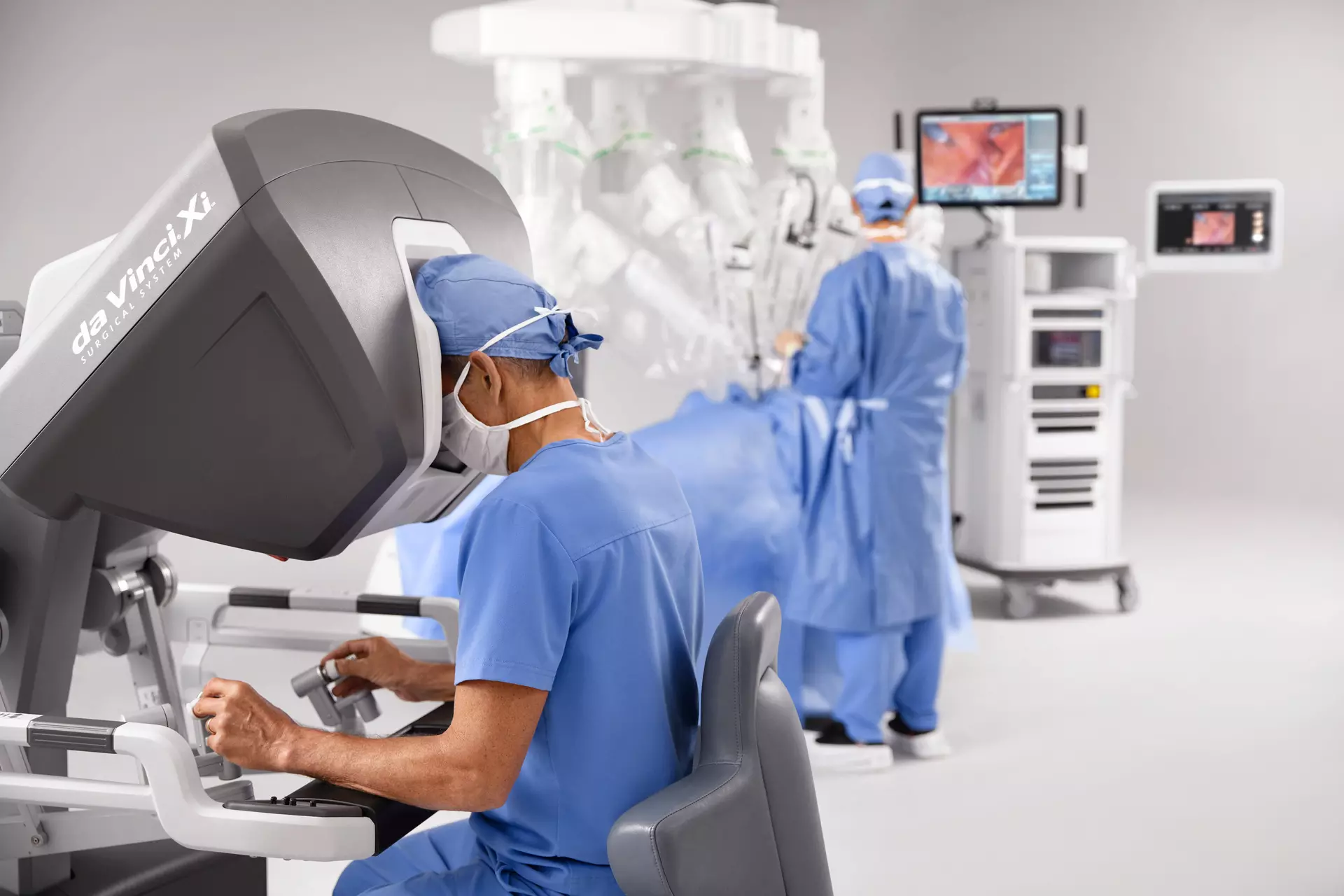 Doctors working in the da vinci Xi robotic machine in a clean room.