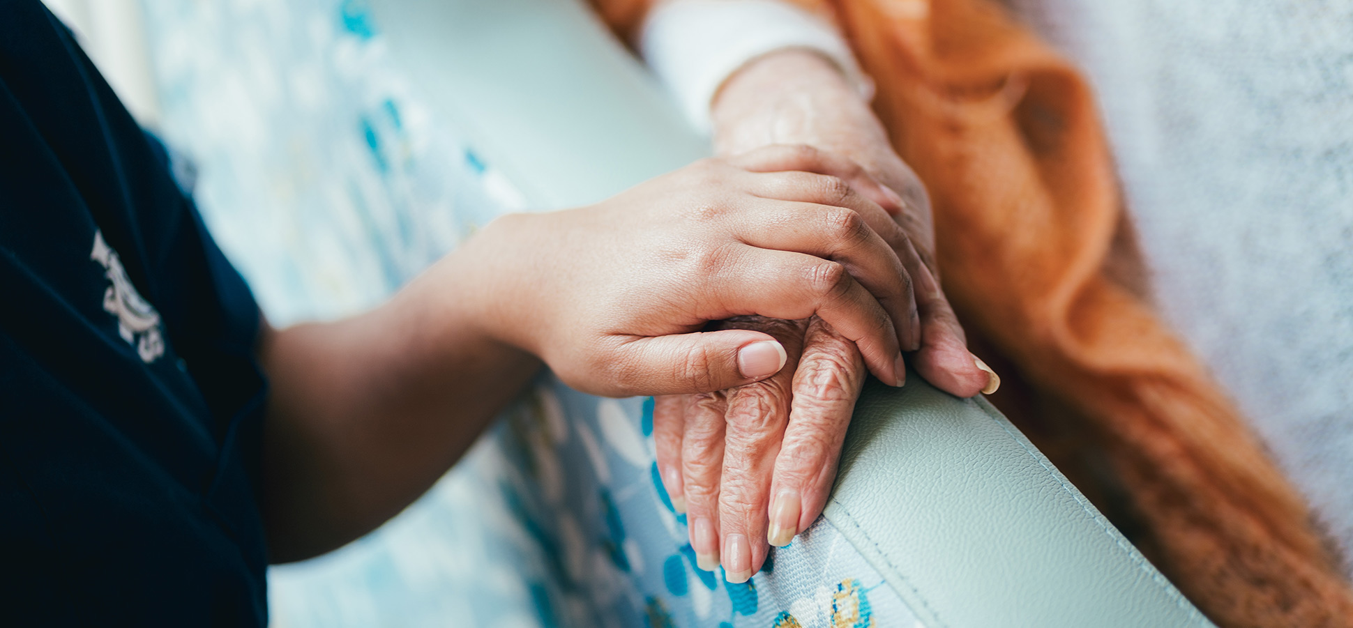 A caregiver holding a patient's hand